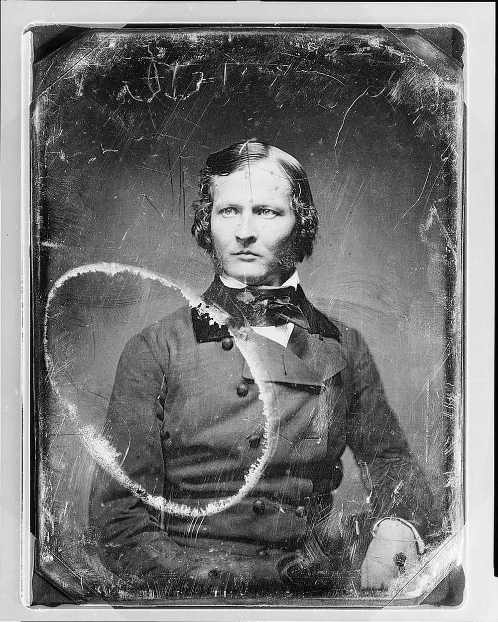 A daguerreotype portrait with a large ring stain and scratches, before restoration