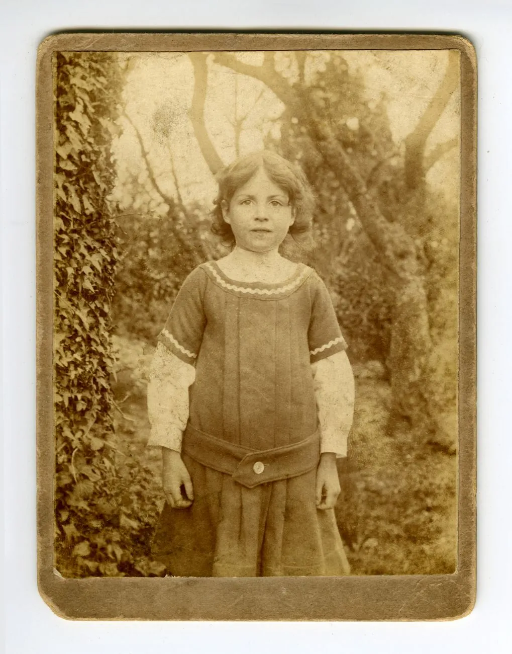 An antique sepia portrait of a girl in period clothing