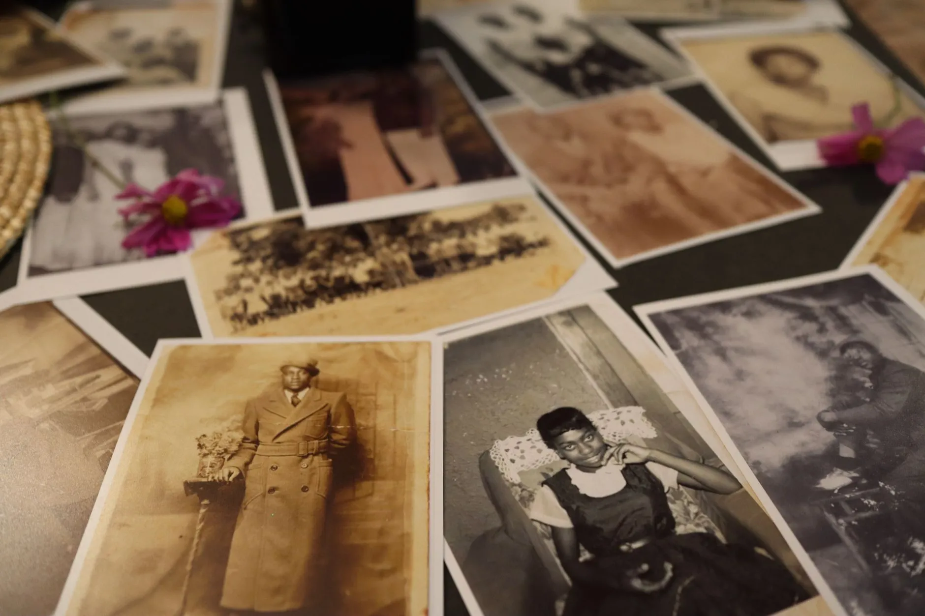 Faded sepia family portraits spread across a dark table