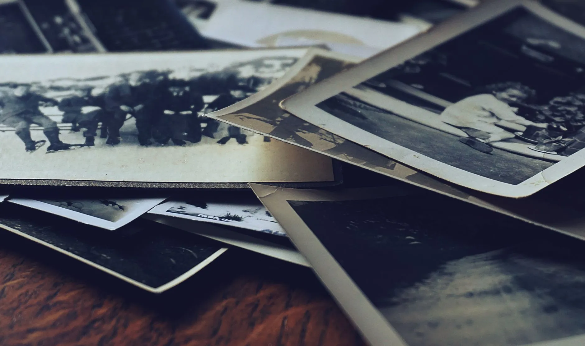 A tight stack of black and white photographic prints with their edges overlapping and interleaved