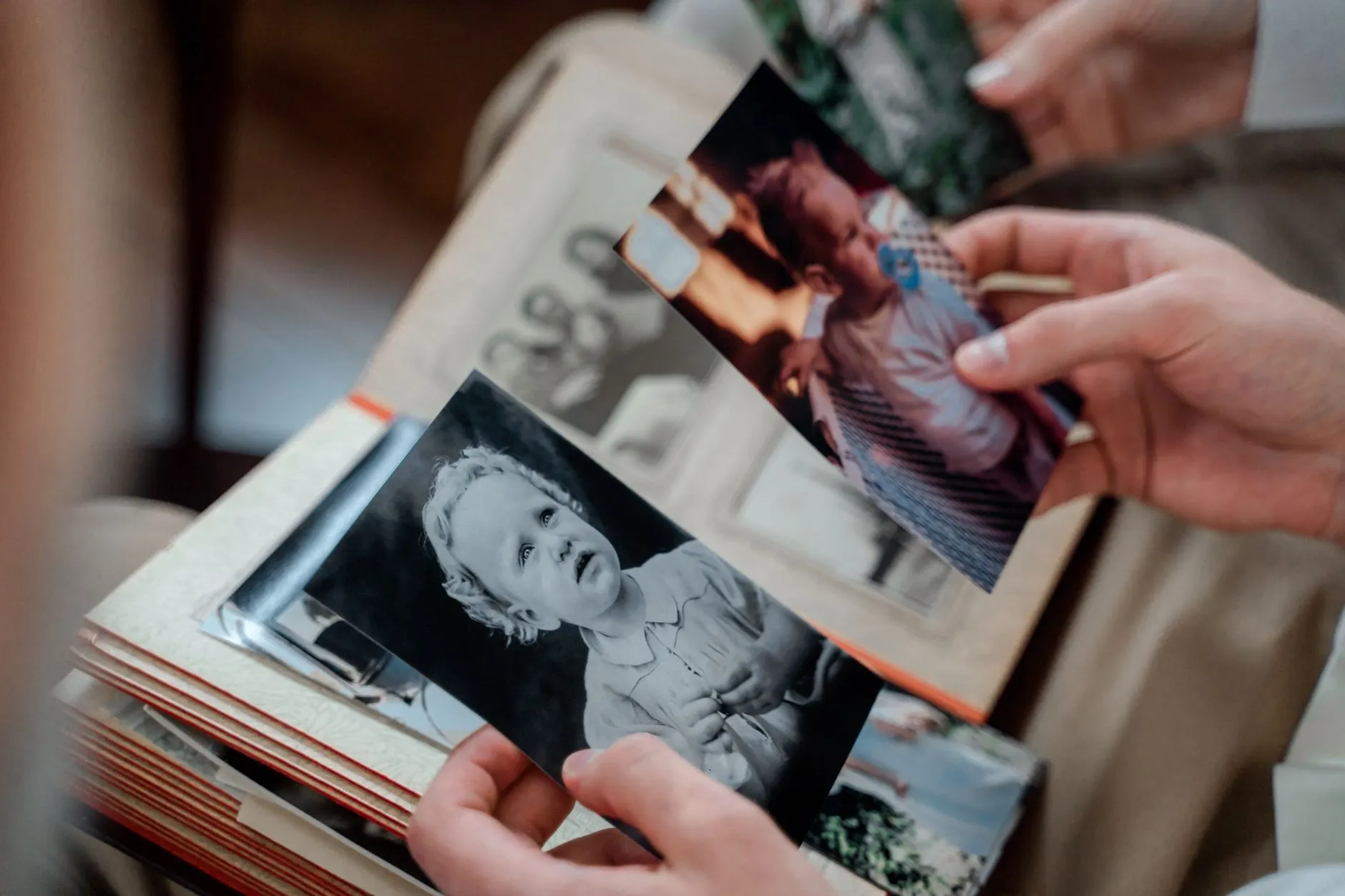 Two people looking through an old family photo album together