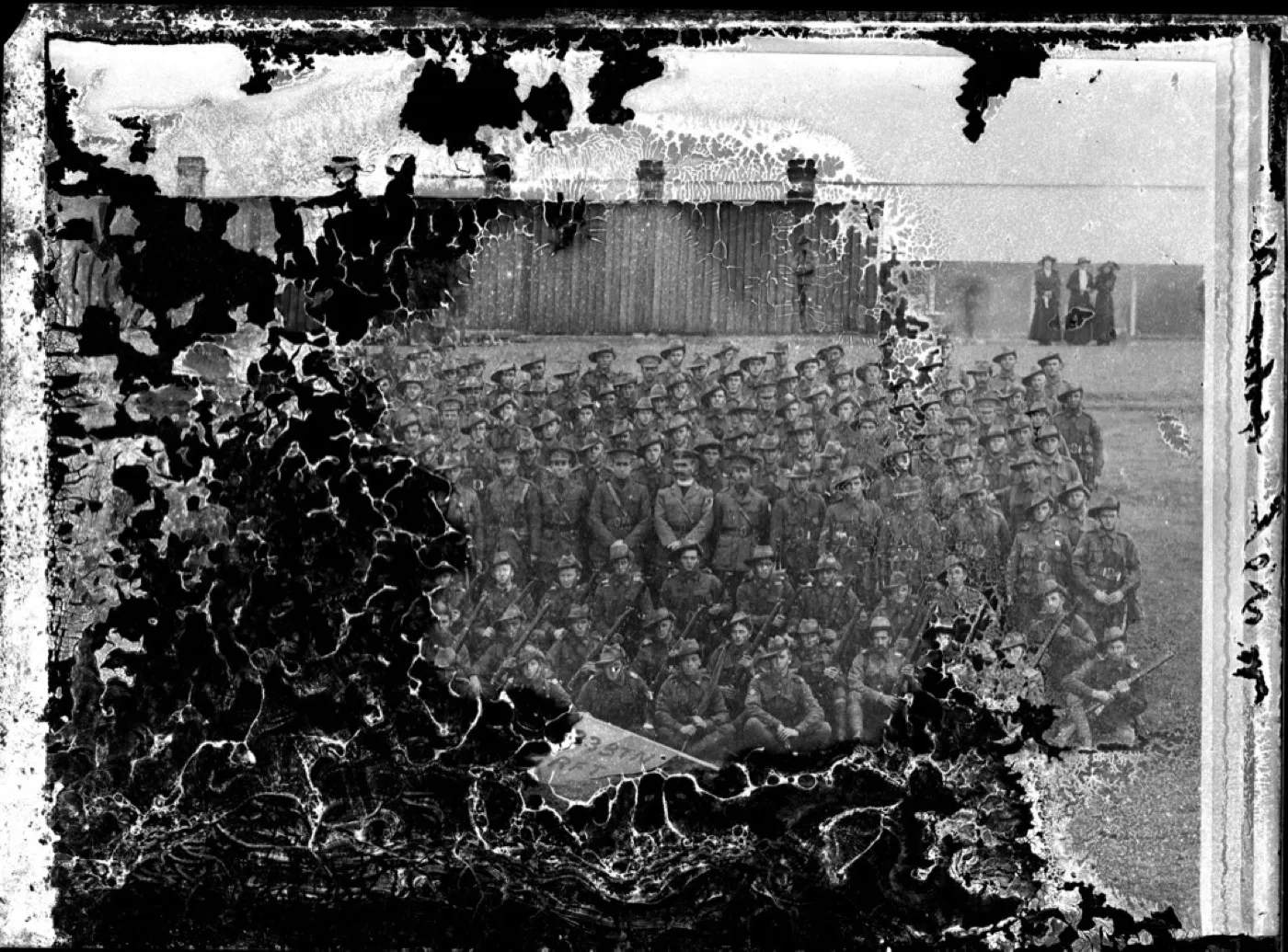A 1915 battalion photograph with whole areas of emulsion flaked away